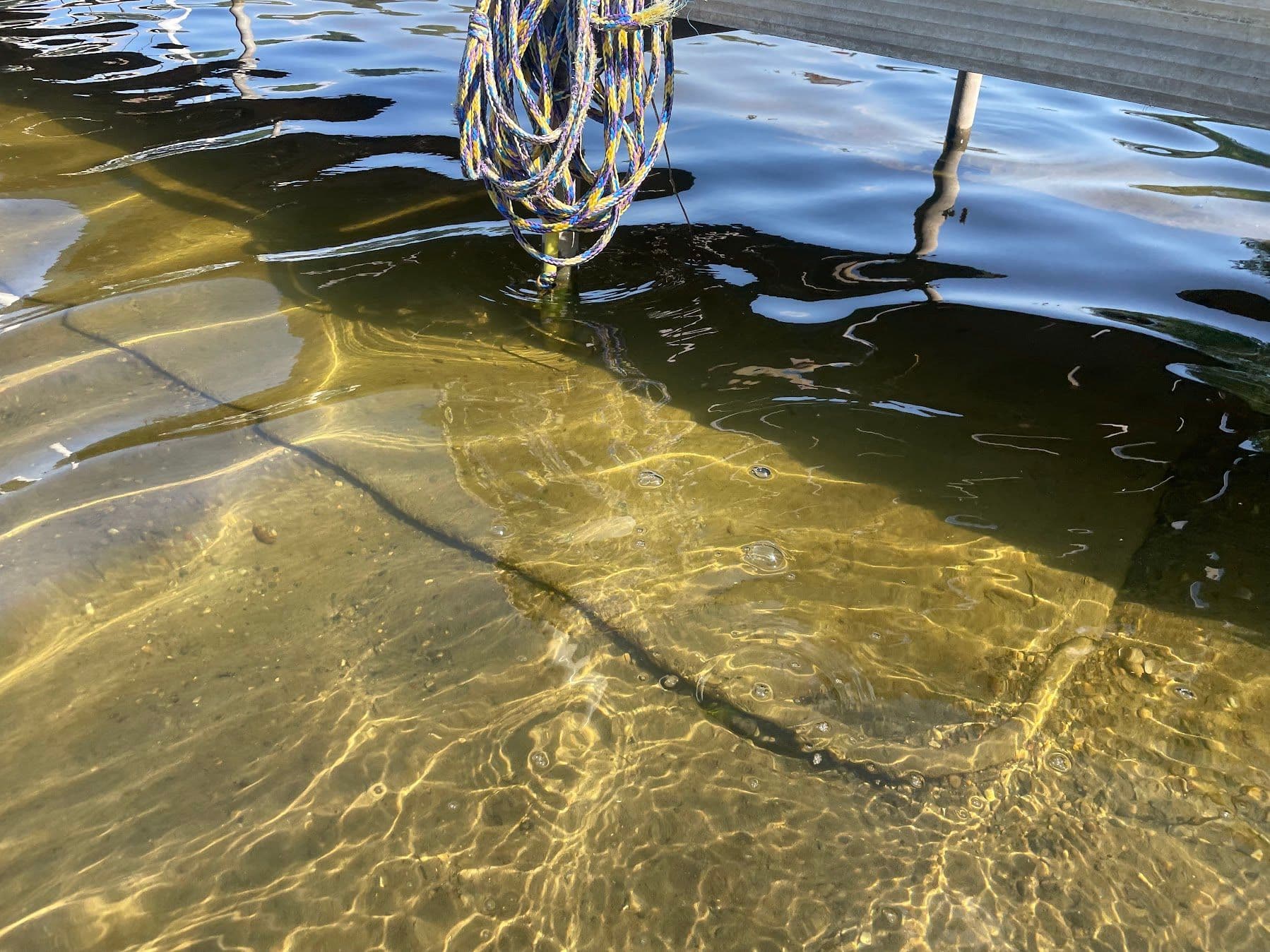 DockMat lays below dock, holding the dock up over muck